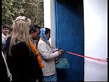 Mrs. Chowdhury cutting the red ribbon of a classroom