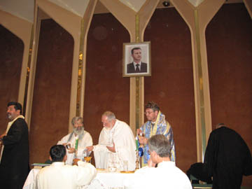 Biskopar and orthodoxa präster firar mässa på en scen på hotellet